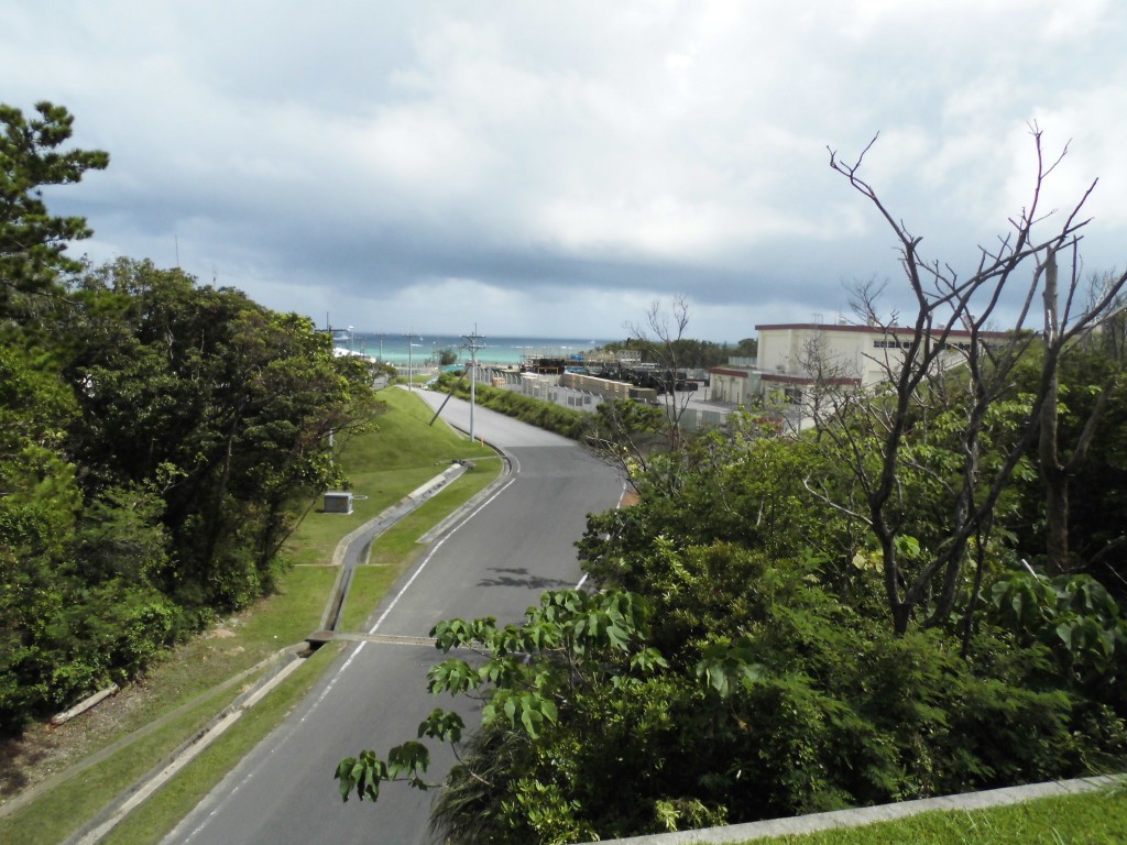 金網の隙間から、キャンプシュワーブ・基地の中をのぞく。向こうに見える海が埋め立てられる。