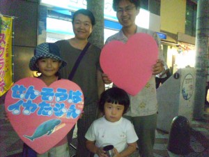 沿道で家族連れがデモ行進にエールを